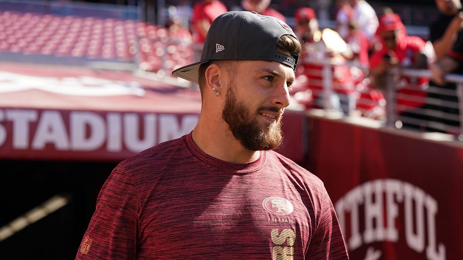 49ers rookie Ricky Pearsall poses with first responders who helped save his life after shooting at game