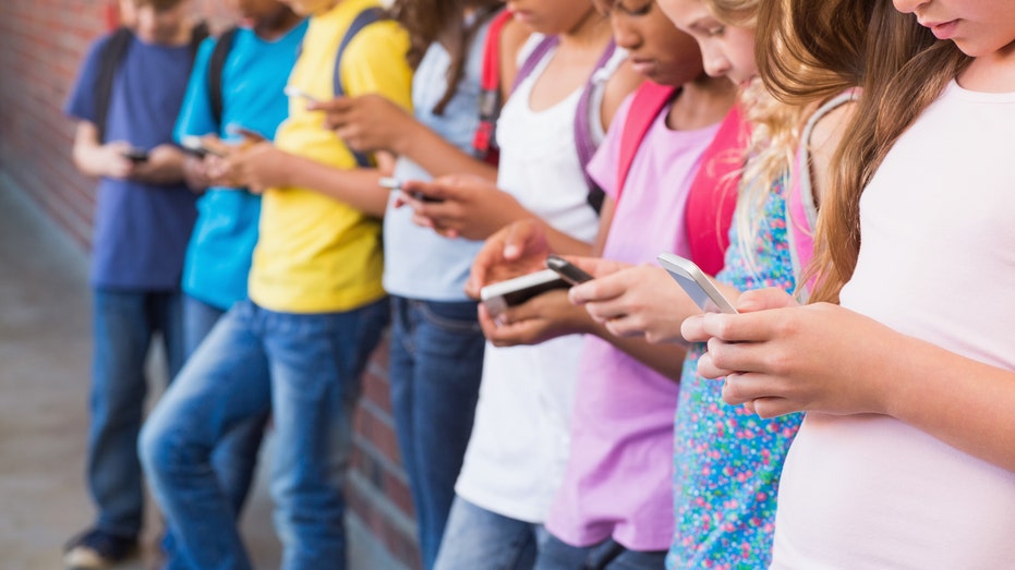 Limiting access to cellphones could help students' grades, social skills and early development, experts say